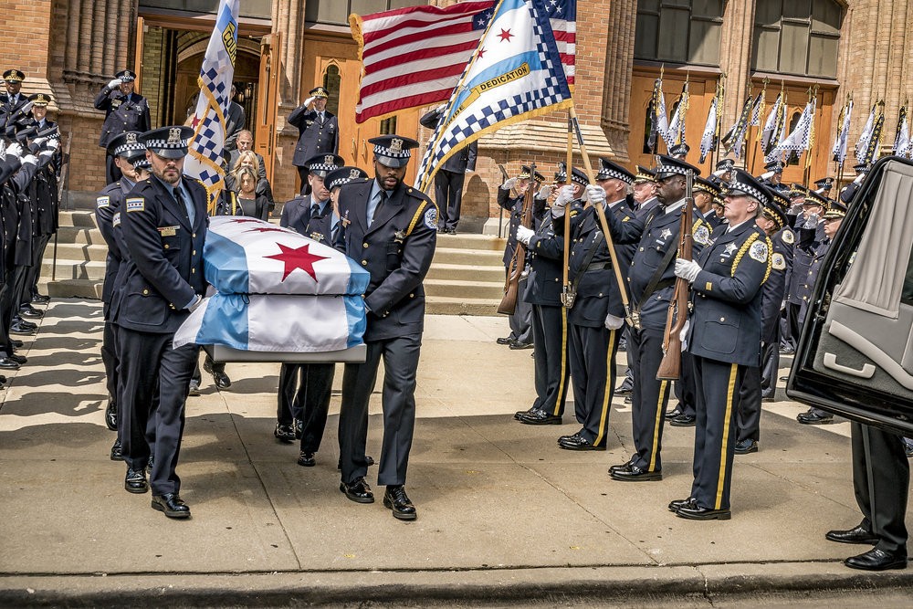 L'équipe porte un cercueil horné du drapeau de la police