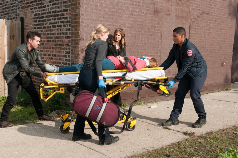 Une victime est transportée sur un brancard grâce à l'ambulancier Peter Mills (Charlie Barnett)