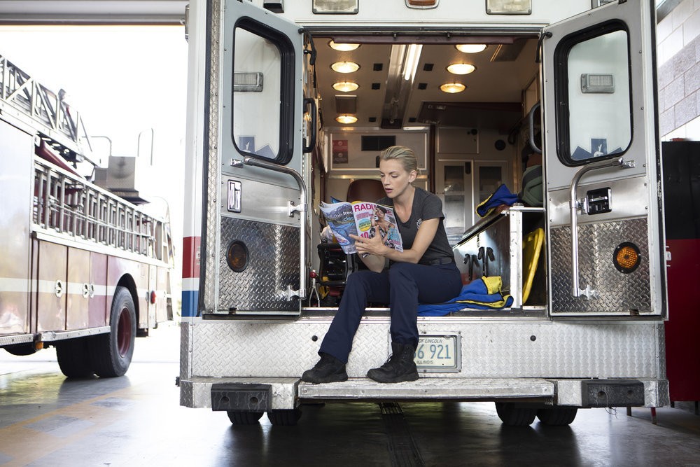 Sylvie Brett (Kara Kilmer) lit un magazine assise dans l'ambulance